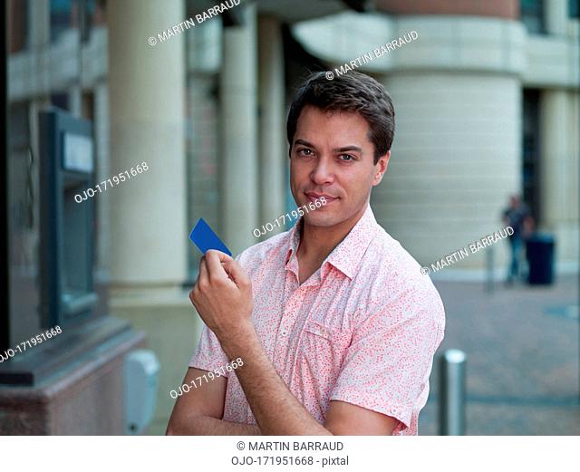 Man holding credit card near ATM machine