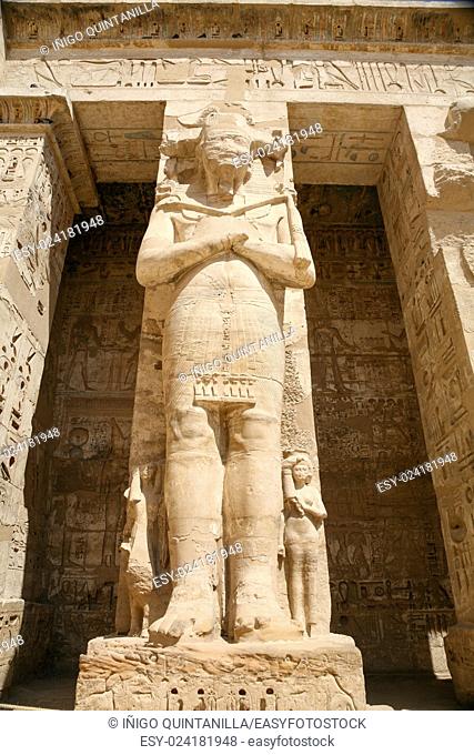 big sculpture statue of landmark Egyptian pharaoh Ramses III, monument in Temple of Medinet Habu, in Luxor, Egypt, Africa
