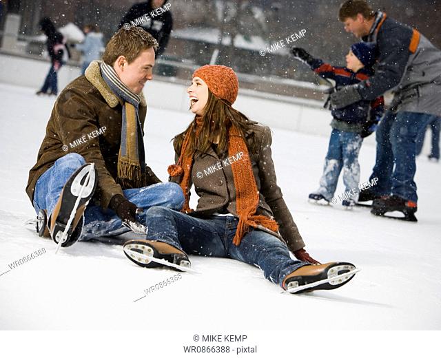 Couple falling while ice skating