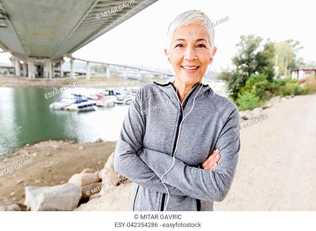 Smiling Senior Woman Relax Listening Music With Earphones After Running, Gray-Short Hair, Wear Sports clothes , Workout Outdoor