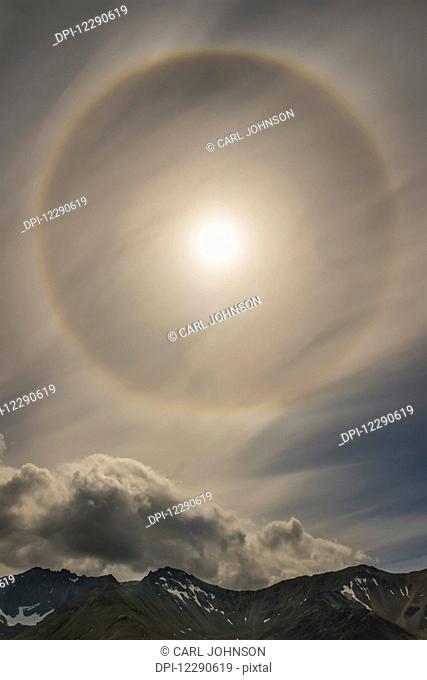 A 22 degree halo fills the sky over the Chigmit Mountains within Lake Clark National Park & Preserve, Alaska
