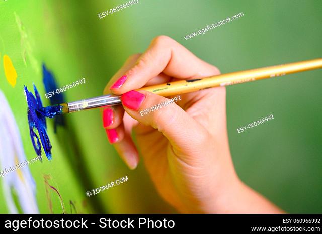 Close-up Shot of Female Artist Hand, Holding Paint Brush and Drawing Oil Painting. Contemporary Painter Creating Modern Abstract Piece of Fine Art