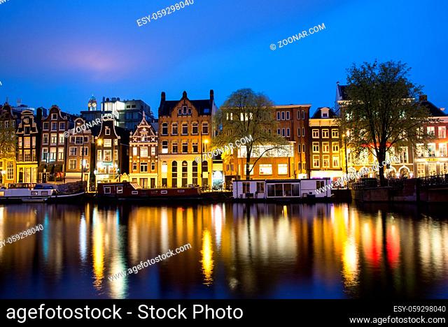 Amsterdam, Netherlands - April 21, 2017: View of the Amsterdam canals and embankments along them at night