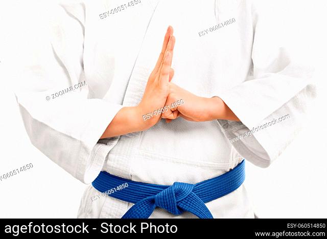 A close up shot of a martial arts fighter in a white kimono with blue belt performing a hand salute, isolated on white background