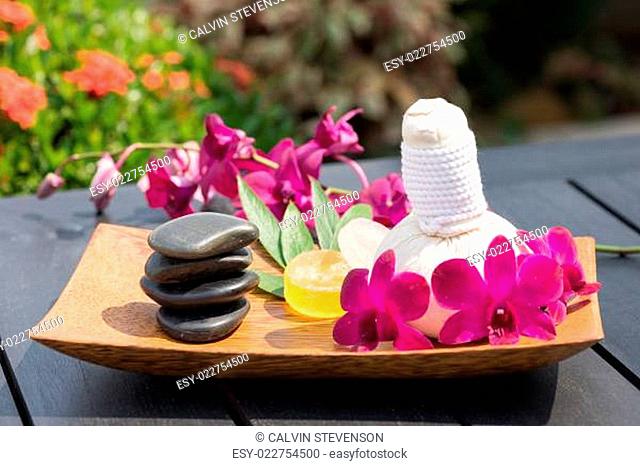 Traditional herbal spa getaway with hot compress balls and orchid close-up