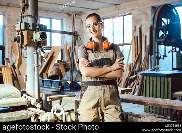 Beautiful proud woman carpenter in her woodwork workshop