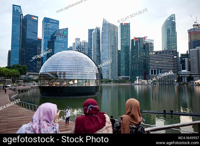 Singapore, Republic of Singapore, Asia - View of the new Apple Flagship Store along the waterfront at Marina Bay Sands with the city skyline of the central...