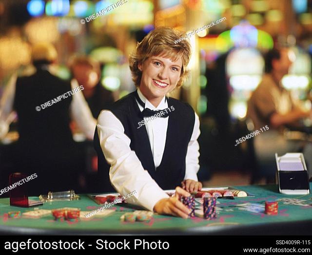 Female casino worker placing gambling chips on a table