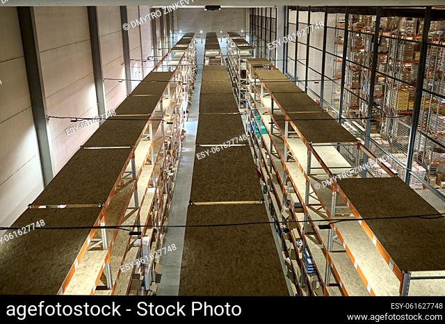 Top view of a modern storage area with numerous shelving units loaded with cardboard boxes with cargo