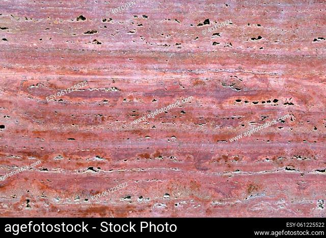 longitudinal cut of pink granite with splashes. The surface of an old veined granite slab