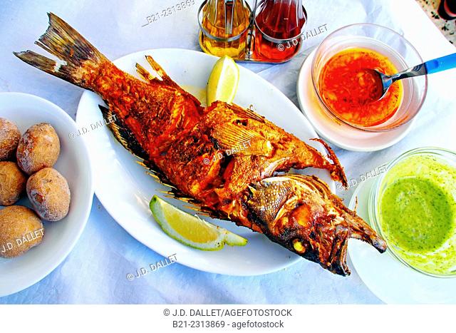 Grilled 'cherne' fish (grouper) with 'papas arrugadas' (potatoes cooked in sea water) and red and green 'mojo' sauces, Tenerife, Canary Islands, Spain