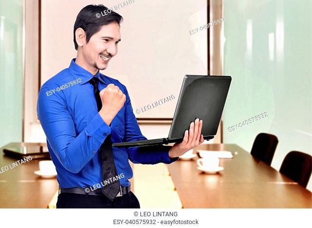 Successful asian businessman with laptop on the workplace
