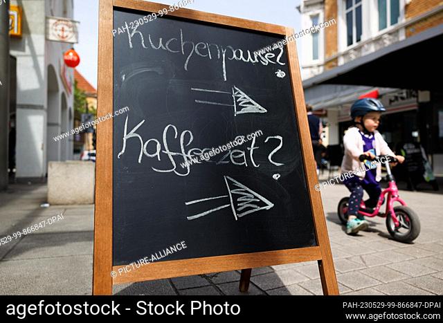 29 May 2023, Lower Saxony, Osnabrück: A ""cake break"" and ""coffee time"" display can be seen in the pedestrian zone. The weather is friendly with sunshine in...