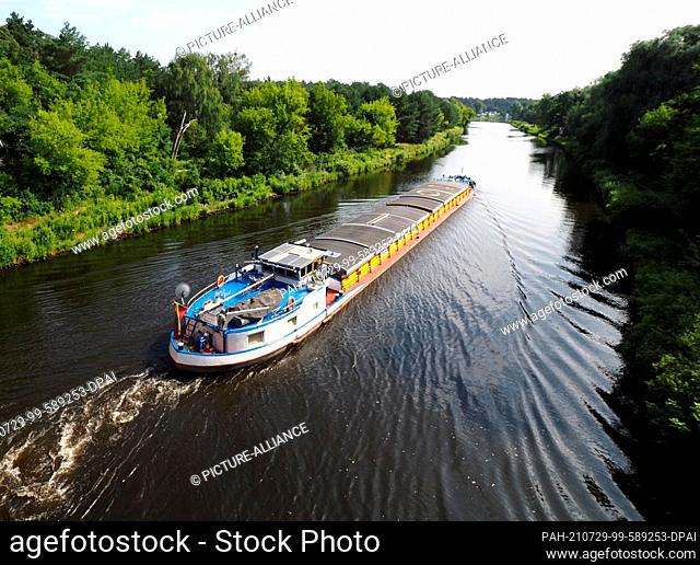 22 July 2021, Brandenburg, Kleinmachnow: The barge ""MS Einigkeit"" (Hamburg) passes the former motorway bridge in the Teltow Canal and heads towards the locks