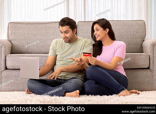 A young man and woman amazed while making online payment with card and tablet phone