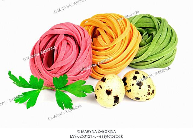 Italian colored fresh rolled fettuccine pasta with quail eggs and parsley isolated on white background