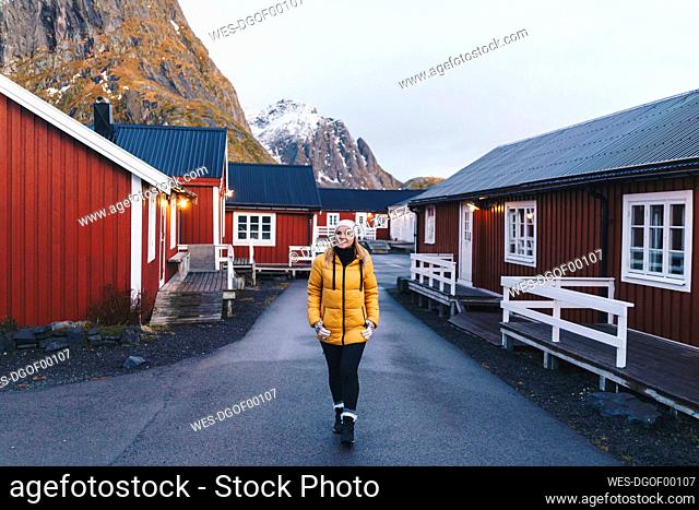 Tourist exploring the fishing village Hamnoy, Lofoten, Norway