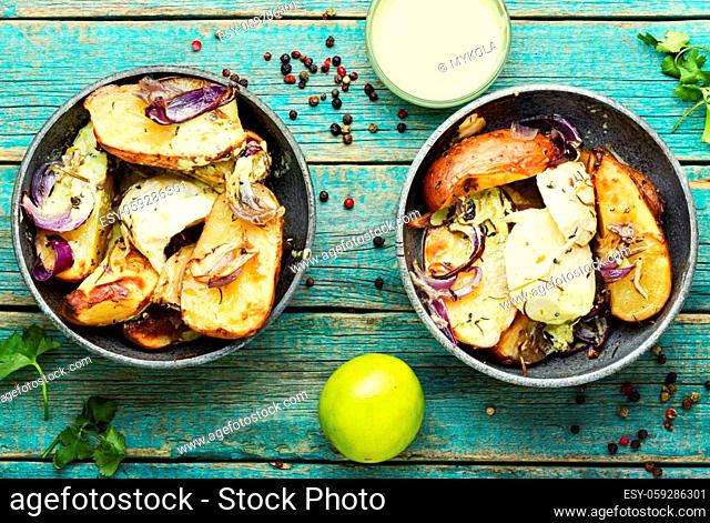 Tasty baked potatoes with mozzarella cheese and onions in plate