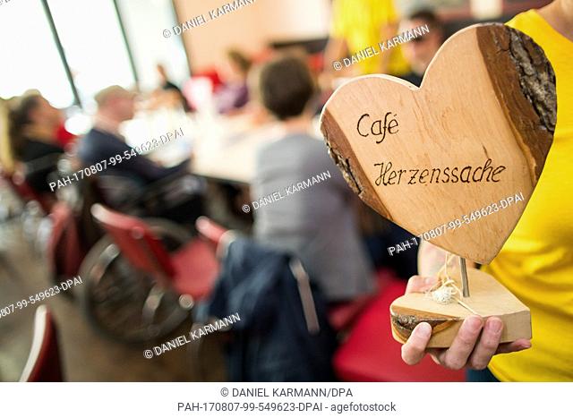 'Cafe Herzenssache' (lit. matter of the heart cafe) can be read on a wooden heart during a meeting of the dating service in Wuerzburg, Germany, 28 July 2017