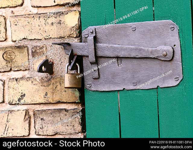 07 September 2022, Berlin: 07.09.2022, Berlin. A lock hangs from the forged latch of a wooden door on a farm. Photo: Wolfram Steinberg/dpa Photo: Wolfram...