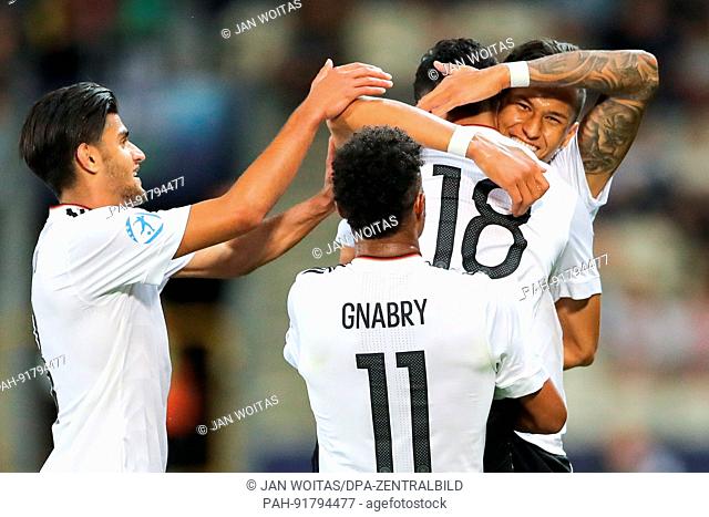dpatop - The German players Nadiem Amiri (M), Serge Gnabry and Mahmoud Dahoud (L) cheer over Amiri's 3-0 score during the men's U21 European Cup Group C match...