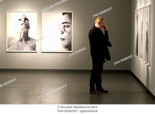 A woman walks past photographs by musician Bryan Adams (NOT IN PICTURE) at NRW Forum in Duesseldorf,  Germany, 01 February 2013