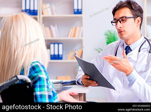 The disabled woman in wheel chair visiting man doctor