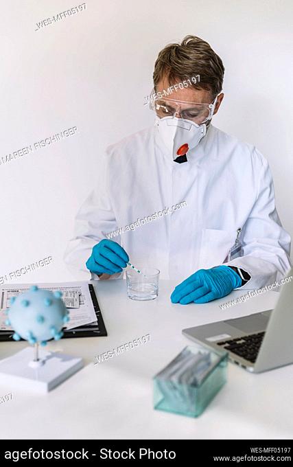 Scientist using lateral flow device at desk