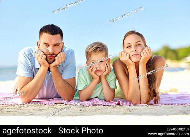 unhappy family lying on summer beach