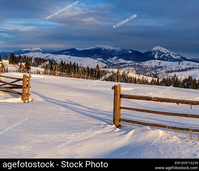 Morning countryside hills, groves and farmlands in winter remote alpine mountain village