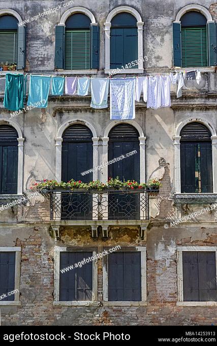 Old venetian house facade with taut clothesline in Venice, Italy