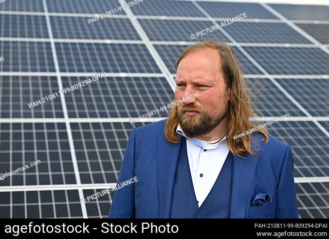 11 August 2021, Brandenburg, Werneuchen: Anton Hofreiter, parliamentary group leader of Bündnis 90/Die Grünen, stands in front of photovoltaic modules on the...