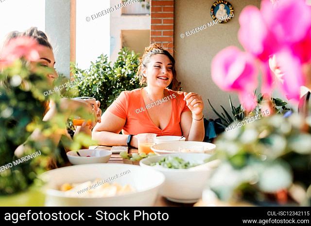 Young woman at meal on balcony