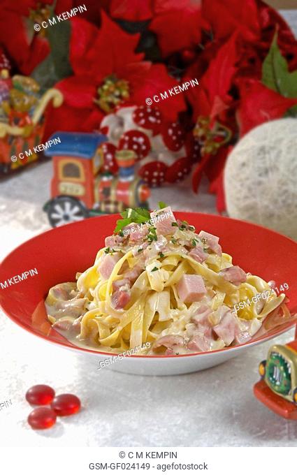 Pasta ribbon noodles tagliatelle with cooked ham and bacon
