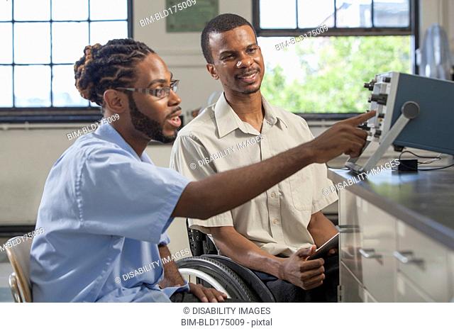 Paraplegic student and classmate working in science classroom