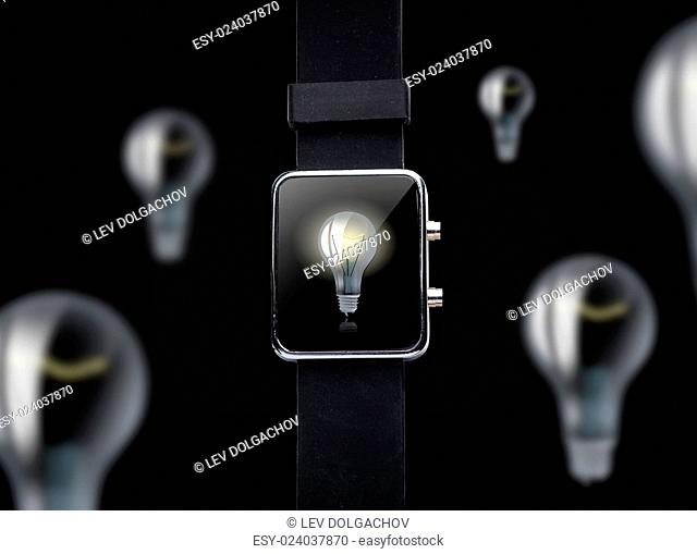 modern technology, business, idea, object and startup concept - close up of black smart watch with light bulb on screen