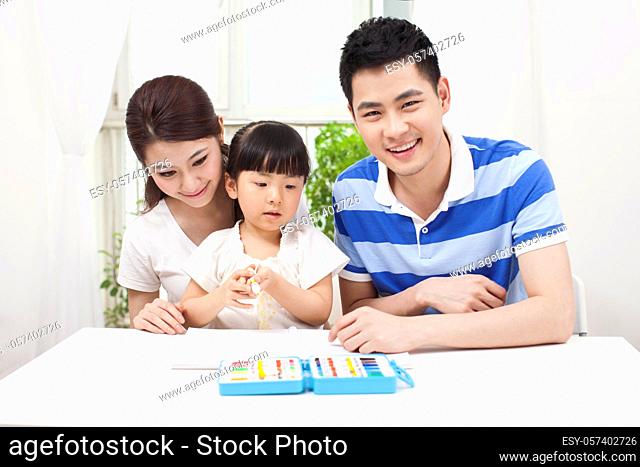 A happy family of three drawing together high quality photo