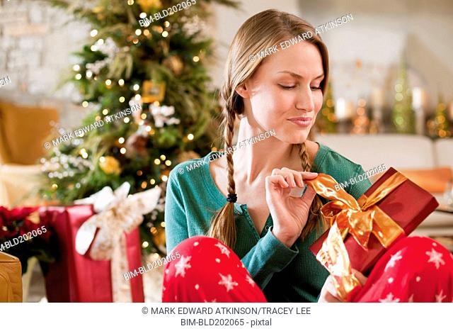 Caucasian woman opening Christmas gift