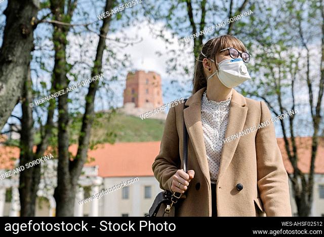 Woman wearing FFP2 mask looking sideways in the city