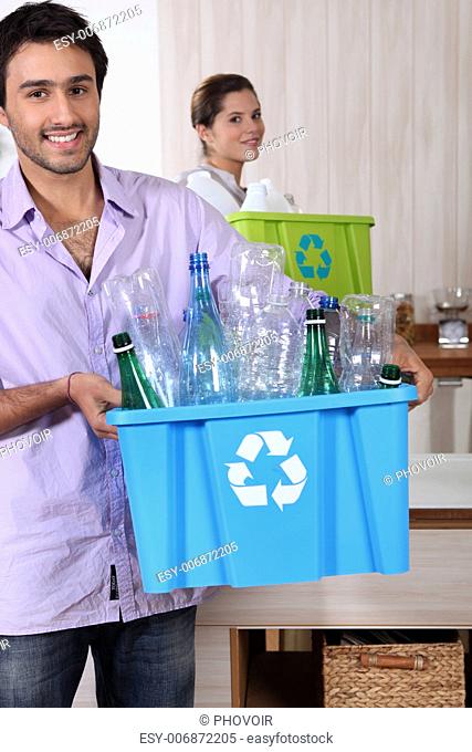 Couple recycling plastic bottles