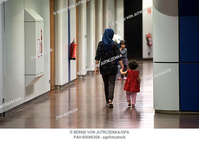 A woman and her children walk through the Internationalen Congress Centrum (ICC) that has been turned into an emergency refugee shelter in Berlin,  Germany
