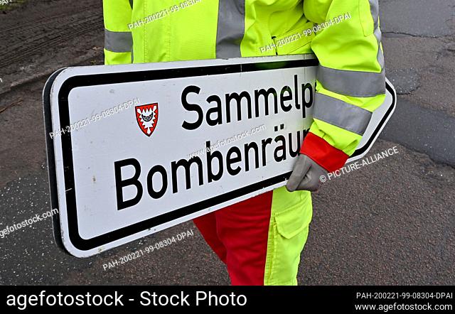 21 February 2020, Schleswig-Holstein, Kiel: A helper carries a sign to the meeting point for residents. For the time of defusing a world war bomb near the...