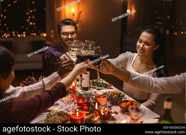 happy friends drinking wine at christmas party