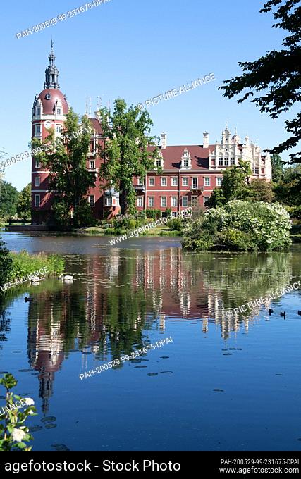 29 May 2020, Saxony, Bad Muskau: The castle in the Fürst-Pückler-Park, built in 1520, is reflected in the water. Photo: Sebastian Kahnert/dpa-Zentralbild/dpa