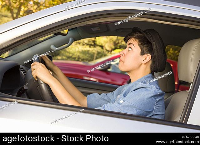 Very stressed mixed-race woman driving in car and traffic