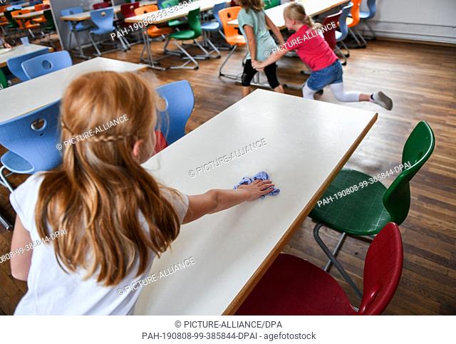 07 August 2019, Berlin: A pupil wipes the table after lunch in the cafeteria of the primary school at Wuhlheide. Photo: Jens Kalaene/dpa-Zentralbild/ZB