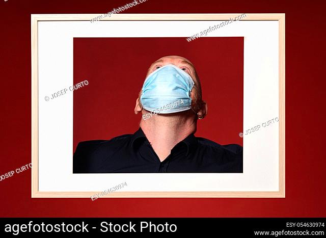 picture of a portrait of a man with mask look up on a red background