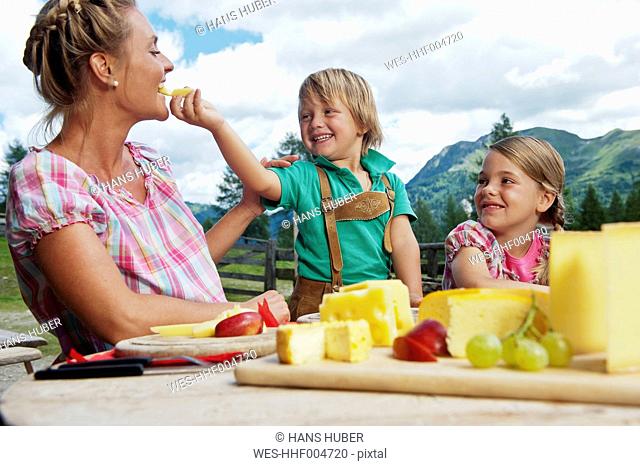 Austria, Salzburg State, Altenmarkt-Zauchensee, mother with two children having an alpine picnic