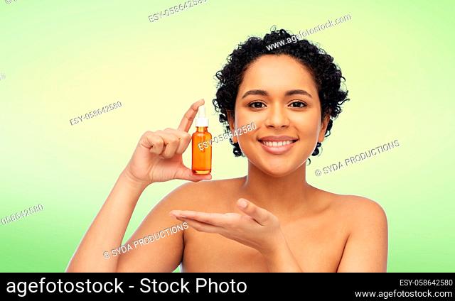 happy african american woman with bottle of serum