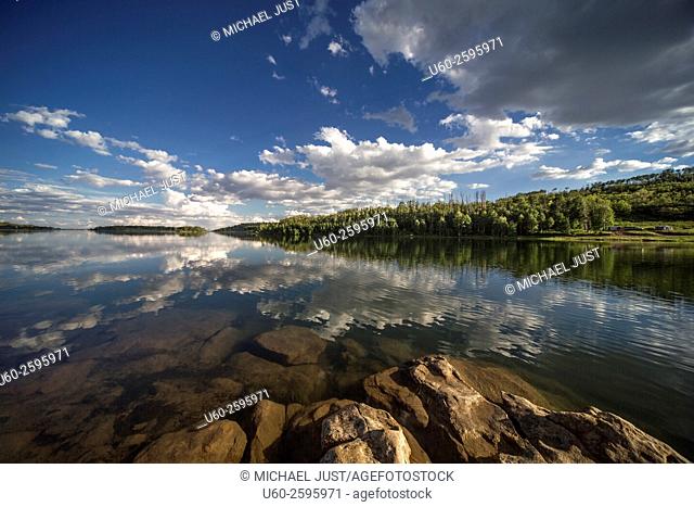 Passing clouds are reflected in the still waters of Kolob Reservoir near Zion National Park, Utah